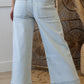 Light blue wide-leg jeans worn by a person indoors with woven baskets in the background.